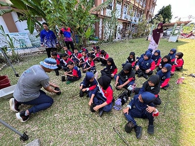 Children participating in reef conservation education program outdoors.